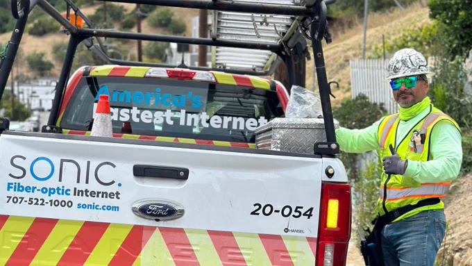 Sonic field service team member in Los Angeles County standing beside the Sonic truck and throwing up a thumbs up 