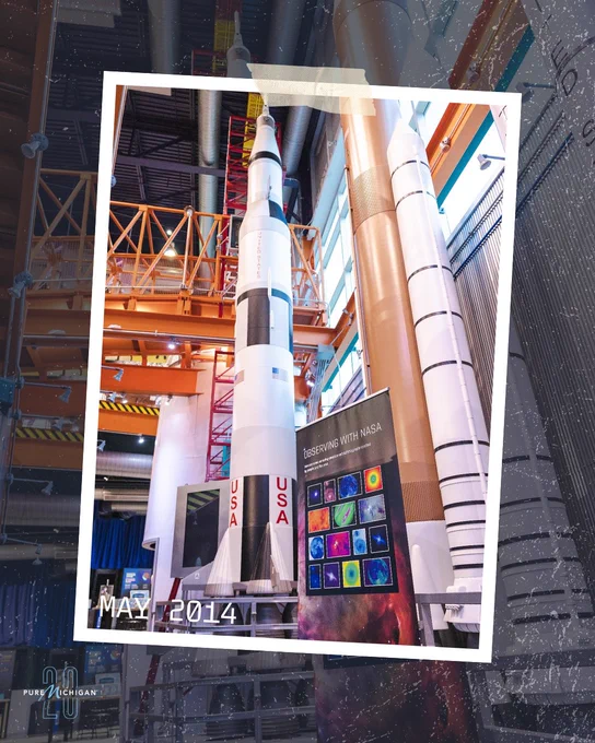 Saturn V rocket exhibit towering inside the Michigan Science Center with signage and displays surrounding the historic installation