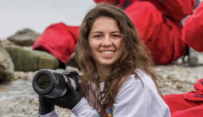 Beautiful Danielle holding up a camera and smiling.