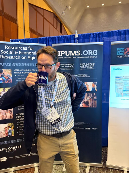 Jonathan Schroeder hard at work at the IPUMS booth with a cup of coffee in hand (in a PAA mug, of course!). 