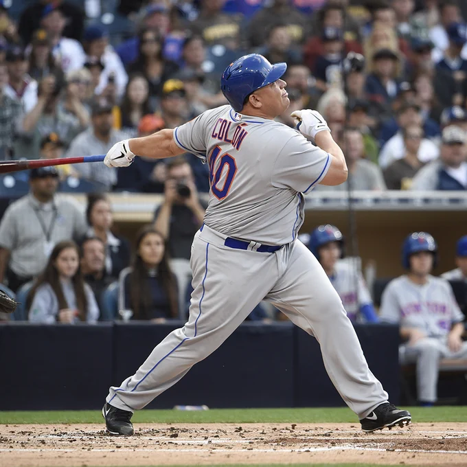 Bartolo Colon finishes his swing after hitting the only home run of his MLB career. He wears a gray New York Mets uniform with blue lettering and orange trim.