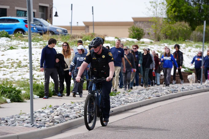 DCSO corporal riding a bike at the STEM community walk. 