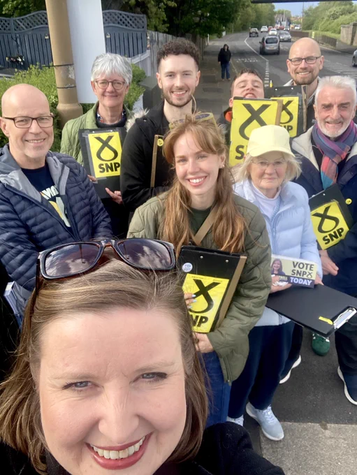 Kate and activists with SNP clip boards smiling at the camera