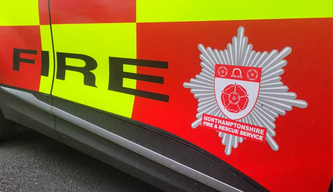 Close-up of a Northamptonshire Fire & Rescue Service vehicle, showing the word FIRE and the service crest.