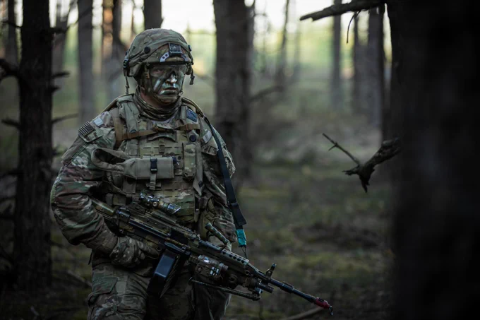 U.S. Army Pfc. Mickey Leonard, an infantryman assigned to Echo Troop, 2nd Squadron, 2nd Cavalry Regiment, patrols through a forested area while carrying an M249 light machine gun during the force-on-force phase of Project Flytrap at Pabrad\u0117 Training Area, Lithuania, May 4, 2026. U.S. Soldiers faced off against British paratroopers from the U.K. Parachute Regiment in a series of simulated engagements designed to test counter-unmanned aerial system integration in a contested environment. From April 27 to May 31, 2026, U.S. and Allied forces will conduct Project Flytrap as part of a series of linked exercises, including Sword 26, Saber Strike, Immediate Response, and Swift Response, which transform experimentation into capability. During Project Flytrap, Soldiers integrate counter-unmanned systems, AI-enabled command and control, and live data networks to move faster, decide faster, and fight more effectively across all domains. (U.S. Army photo by Sgt. Max Elliott)