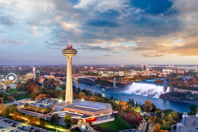 Downtown Niagara Falls, Canada at sunset with falls showcased in background.