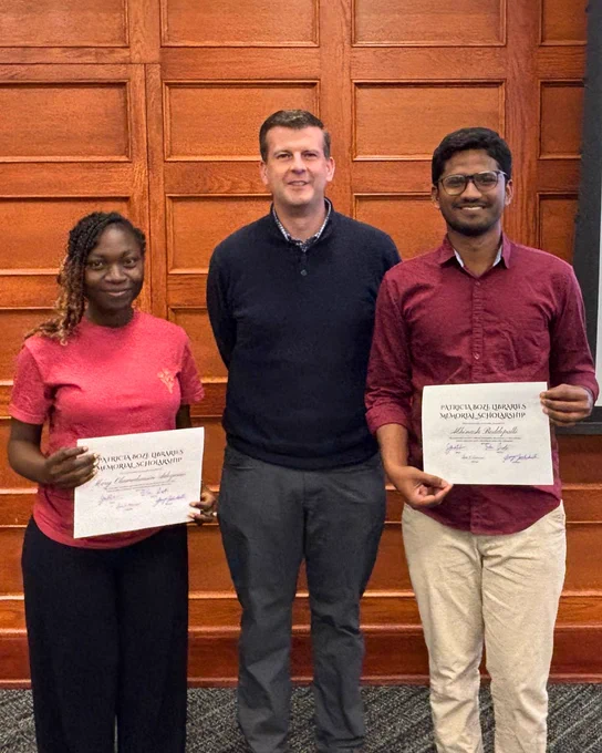 Two K-State Libraries Student Ambassadors, Mary Adeyemo and Abhinash Boddepalli, stand with Dean James Wiser while holding their Patricia Boze Libraries Memorial Scholarship certificates.