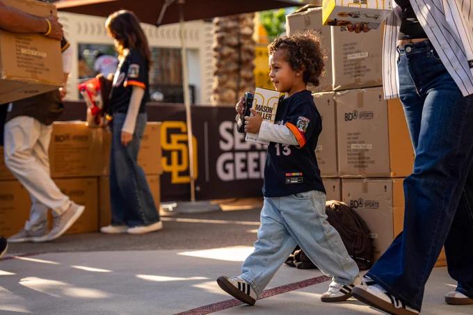 A young fan walking with the Mason Miller bobblehead.