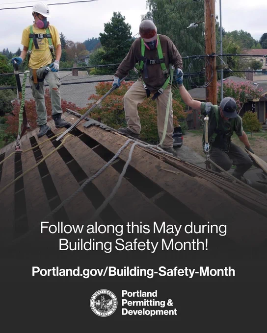 Three men wearing safety gear, harnesses, and hard hats climb on top of a residential house roof, working on a home improvement project. Follow along this May during Building Safety Month! Portland.gov/Building-Safety-Month
