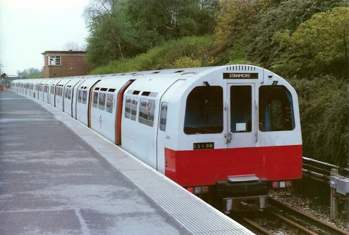 A new-looking 1983 stock stands at platform 1 Stanmore. The single-leaf doors are open showing the orange interior surrounds to the doors. Like the D78 and 73 stock at the time, the entire train is unpainted aluminium save for the lower half of the cab end painted red.