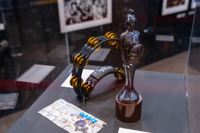 Images from the '1996' exhibition at Barbican Music Library, including Geri Halliwell's platform boots and Liam Gallagher's tambourine. 