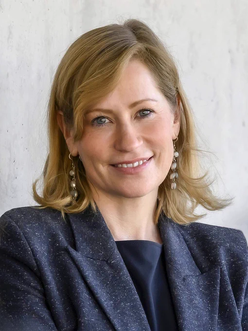 Dr Melina Schuh, pictured smiling, wearing a blue jacket. Head and shoulders image.