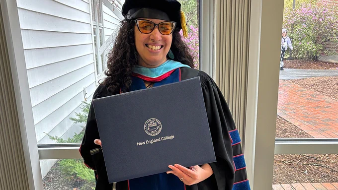 Yokasta Urena holding her diploma