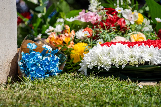Gerbes de fleurs déposées devant la stèle commémorative