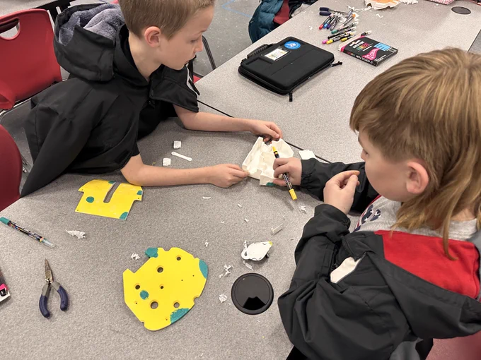 Two students work on designing their BattleBots. 