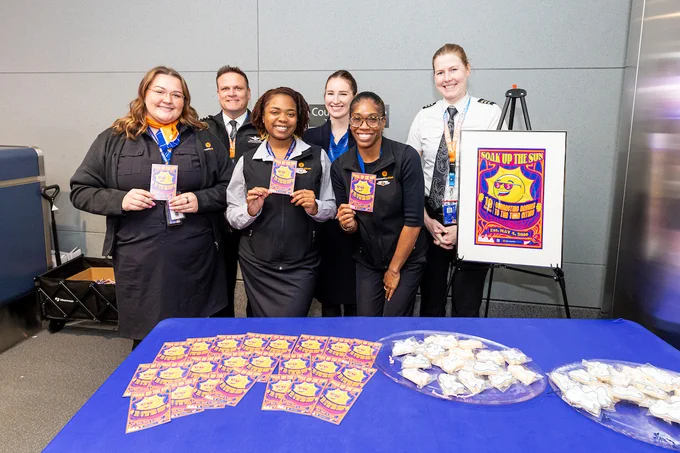 Sun Country crew pose at a celebration table at the airport gate.