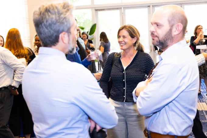 Faculty and staff smiling and mingling.