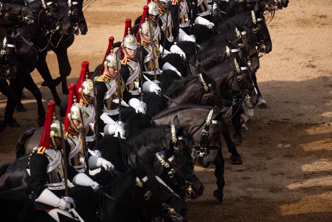 The troopers of the Blues and Royals rank past in formation on their black horses