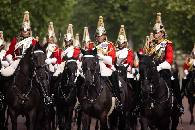 The troopers of the Life Guards rank past in formation on their black horses