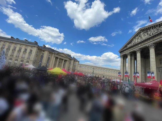Photo de la foule floutée. À droite de l’image le Panthéon surplombant le village antifasciste.