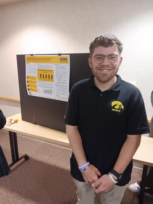 Andy stands next to his poster