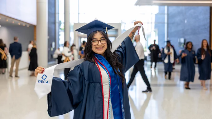 Female Wake Tech graduate smiling in her cap and gown.