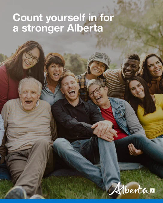 A diverse group of Albertans sitting together outside and laughing.