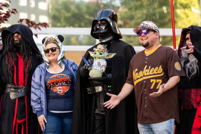 Photo of two Padres fans posing with a group of Star Wars characters.