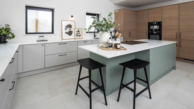 scandi-style kitchen with green island and white worktops

