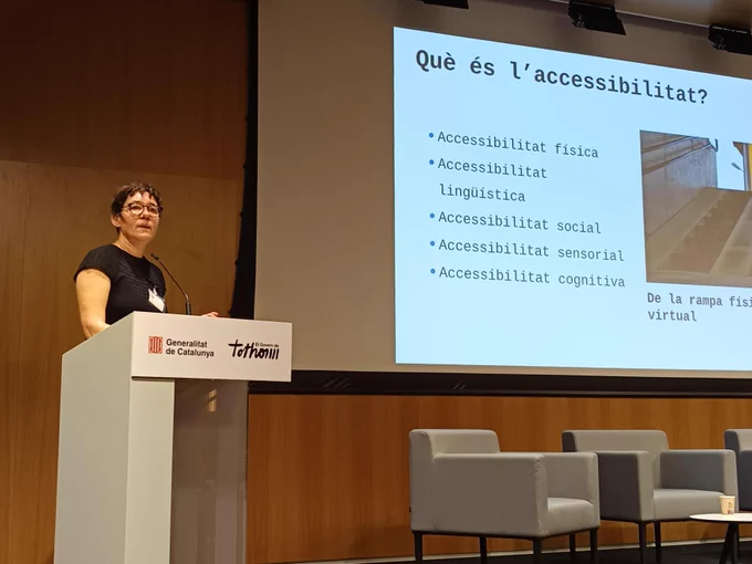 Una dona dona una conferència sobre accessibilitat rere un faristol.