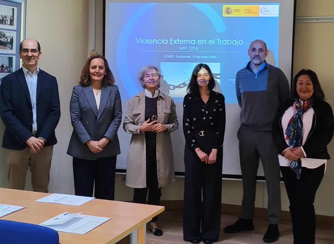María Jesús otero en una foto de grupo junto a otras personas ponente delante de una pantalla de un auditorio o salón de actos.