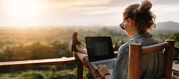 Image of women working remotely from a balcony.
