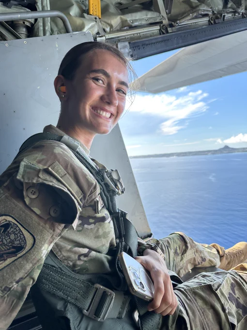 A U.S. Air Force Academy female cadet poses for a photo in the back of a plane/helicopter.