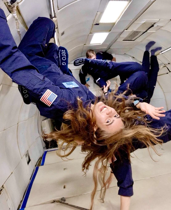 A U.S. Air Force Academy female cadet floats upside down in a zero-gravity plane.