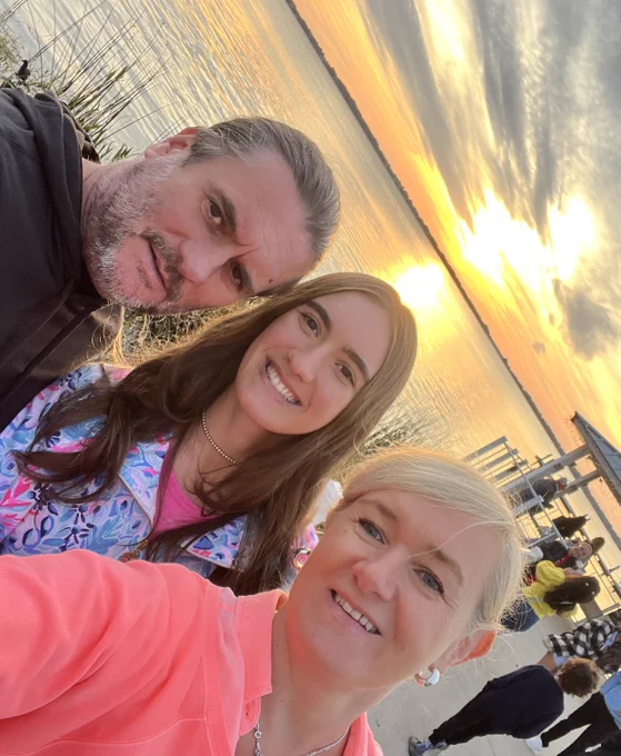 Three people pose for a photo out in nature.