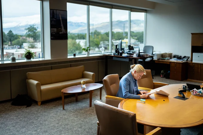 Labs Director Laura McGill reviews papers at a table in her office.