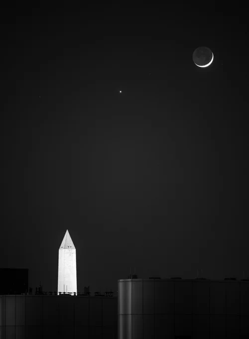 La Luna en fase creciente y Venus aparecen juntos en el cielo nocturno durante una conjunción, en una vista tomada desde el edificio de la Sede central de la NASA en Washington, D.C. 
