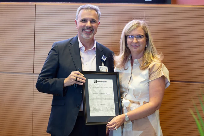 DHIP president, Dr. Matthew Barber, posing with Dr. Nicole Scouras with her SoM Faculty Award.