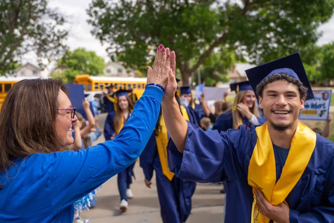 Frederick High seniors visit their former schools in graduation attire.