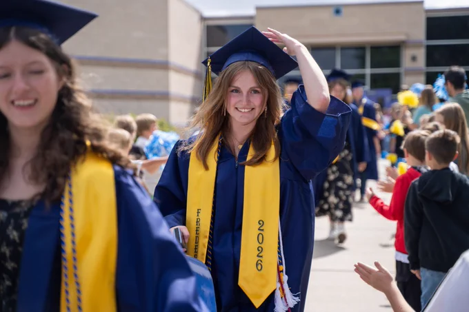 Frederick High seniors visit their former schools in graduation attire.