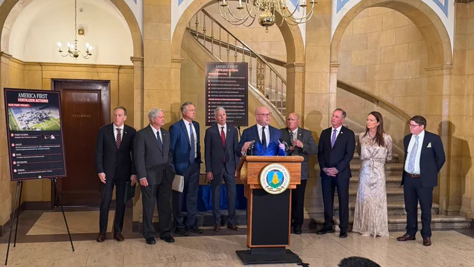 Assistant Secretary of the Army for Civil Works Adam Telle stands in front of a podium as other leaders stand in the background