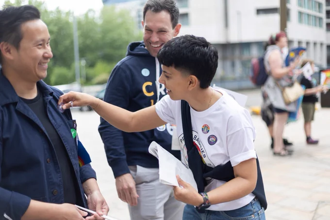 A Proud Baggies member giving out stickers to the crowd at Birmingham Pride 2025.
