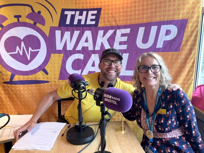Joe Sims and Adele pictured in front of The Wake Up Call sign.
