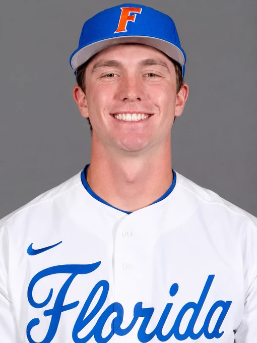 A smiling baseball player wearing a Florida Gators uniform and cap poses against a neutral background. The image portrays a positive and professional mood.