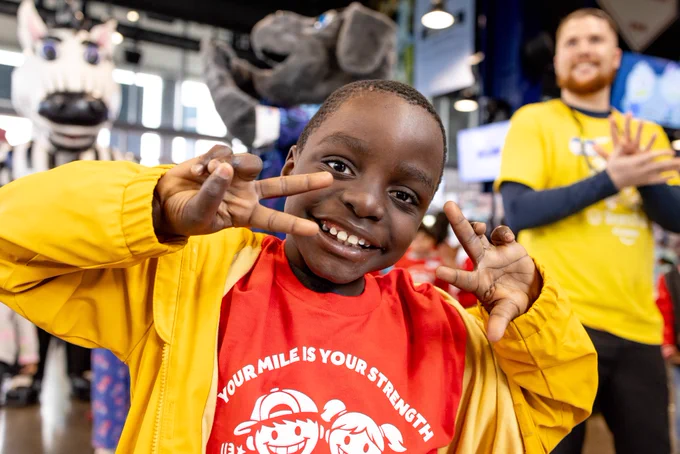 A young child smiles and poses for a photo.