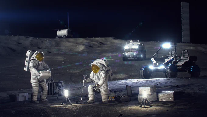 Representación artística en la que se ve a dos astronautas con traje espacial trabajando en la superficie lunar. Uno de ellos está de pie junto a un foco de iluminación, mientras que el otro está arrodillado. El paisaje montañoso que los rodea está salpicado de equipamiento, como vehículos exploradores y módulos habitables. Crédito: NASA