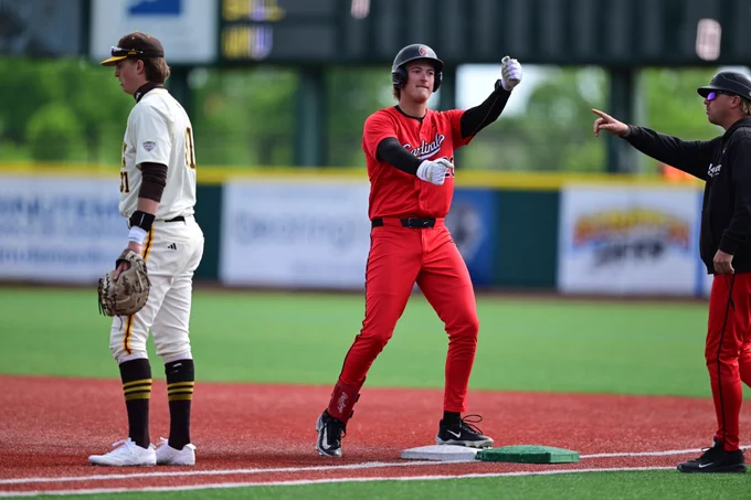 Jack Bakus in a red Ball State baseball uniform celebrating getting on base after a hit