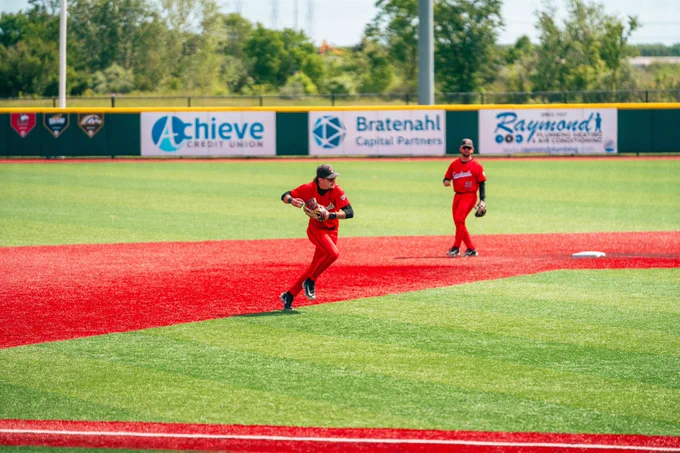 Brett Griffiths in a red Ball State baseball uniform fielding a baseball