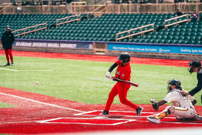 Brady Davidson in a red Ball State baseball uniform swinging a baseball bat