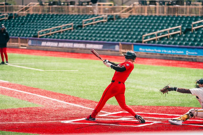 Ryan Muizelaar in a red Ball State baseball uniform swinging a baseball bat
